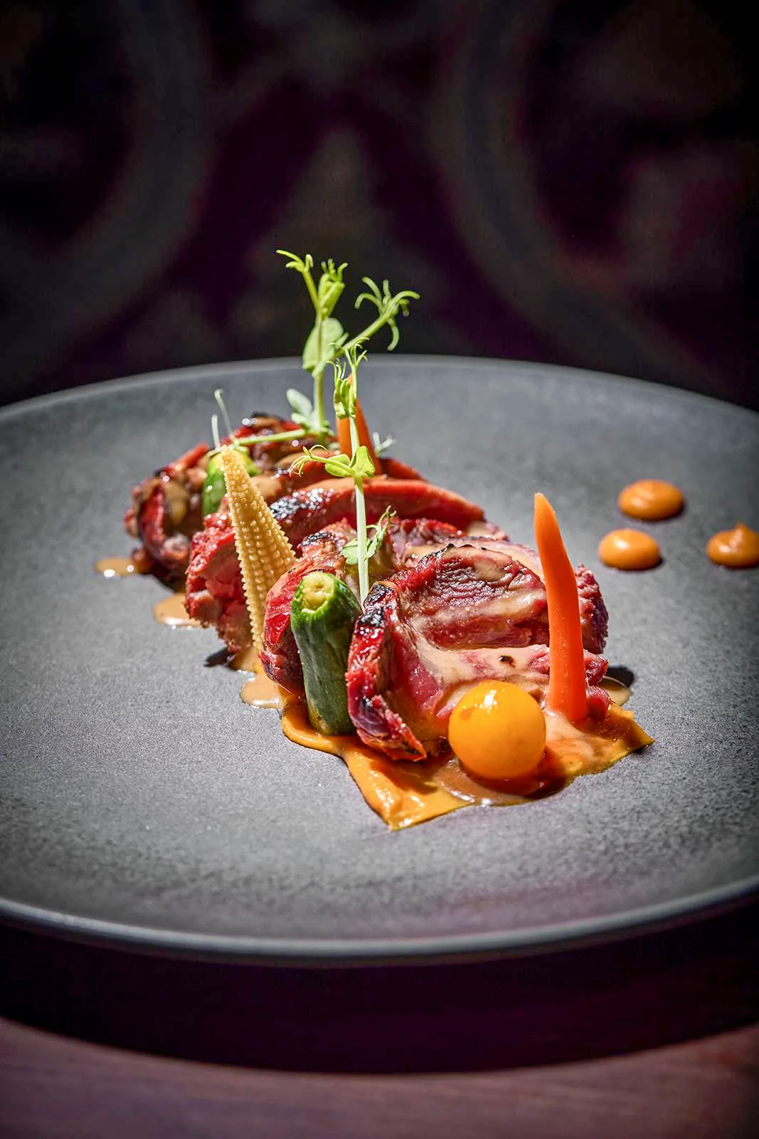 Carne fileteada con verduras, en plato gris