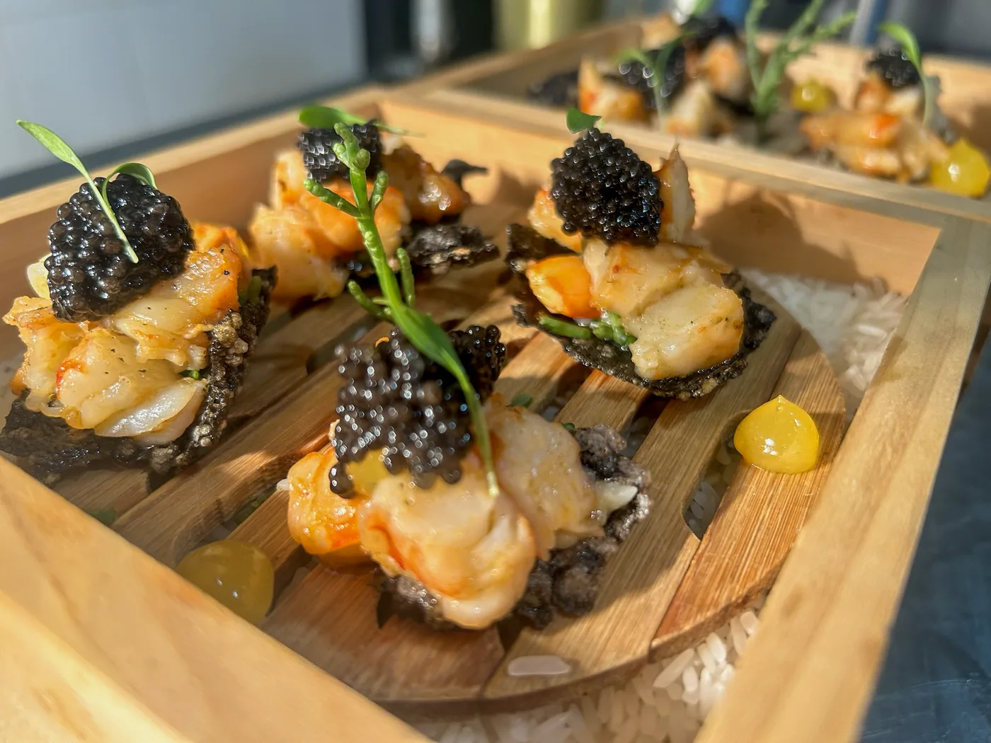 Colas de langostino con caviar sobre tabla de madera