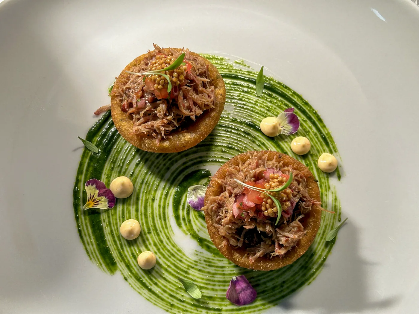 Tartaletas de carne deshilachada sobre salsa verde