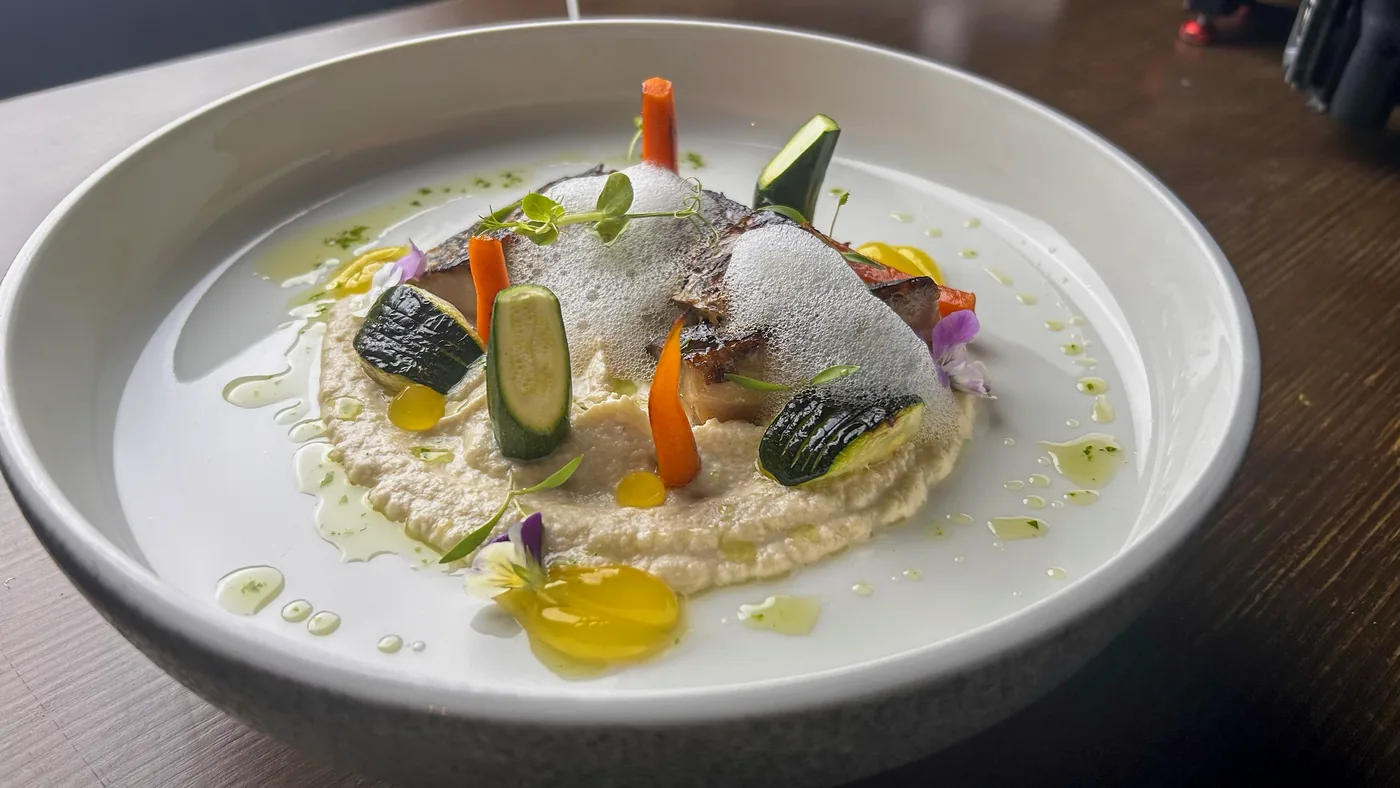 Verduras con crema y flores, en cuenco blanco